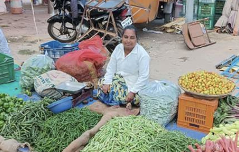 A founder at her vegetable stall with produce laid out for sale