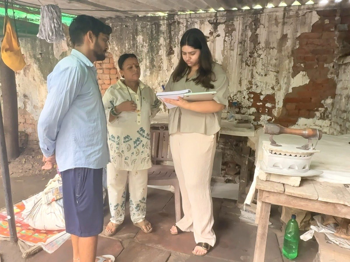 RISE team member in conversation with a woman entrepreneur and community member at her workplace