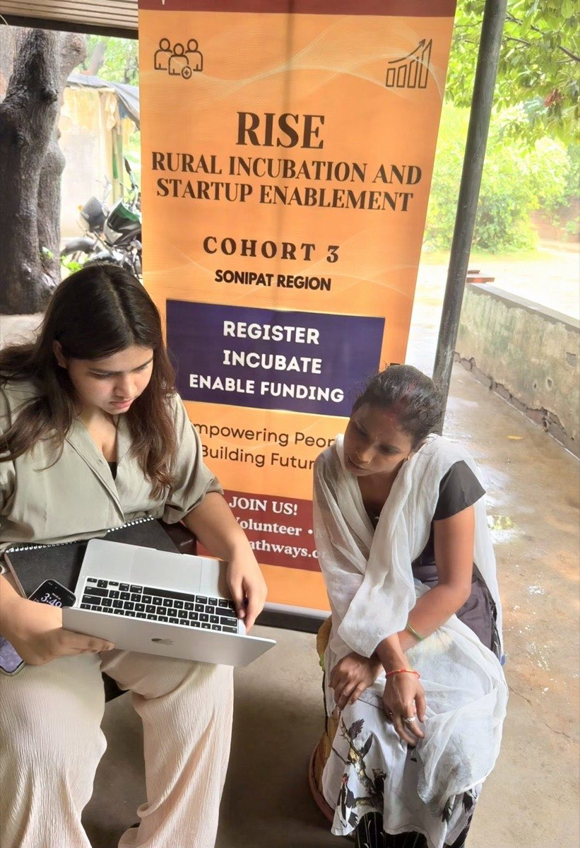 One-on-one registration session beside the RISE Cohort 3 banner